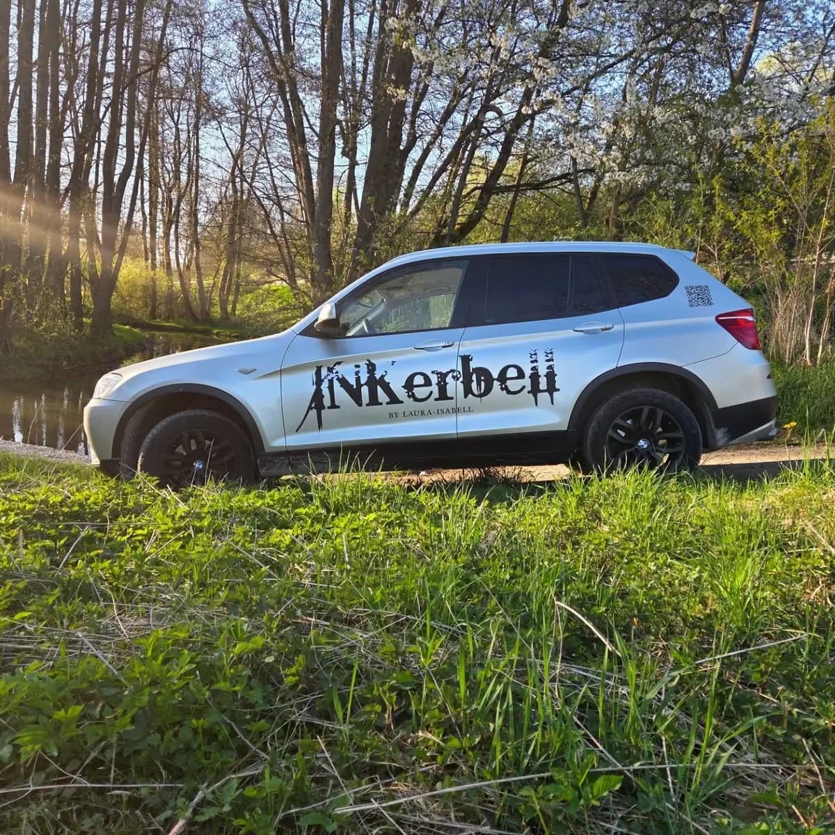 Inkerbell-Fahrzeugbeschriftung auf einem weißen Pkw in einer Außenaufnahme